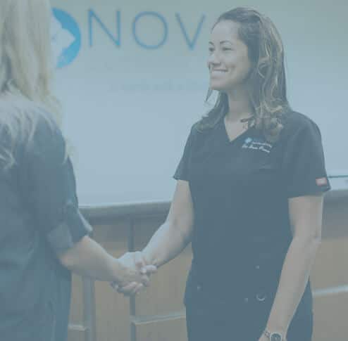 Dr Provo is greeting a client at NOVO Dental Centre Abbotsford under transparent blue overlay