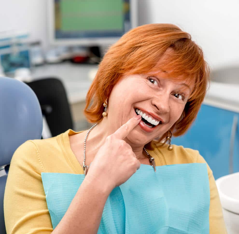 a happy dential patient pointing to a new dential implant